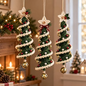 Peut inclure: Trois décorations de sapin de Noël suspendues en crochet vert foncé. Chaque sapin présente une bordure en spirale couleur crème, des perles rouges et argentées, des grelots dorés et une étoile en crochet crème avec un petit bouton en bois.