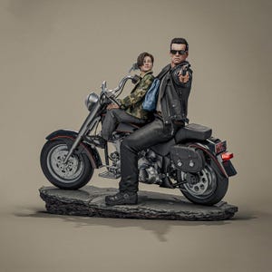 May include: A detailed figurine of two figures on a black motorcycle. One figure, wearing sunglasses and a black leather jacket, points a gun. The other figure wears a camouflage jacket and sits behind the first. The motorcycle is on a stone base.