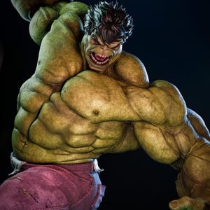 May include: A detailed sculpture of the Hulk in a dynamic pose, showcasing his muscular physique. The figure is predominantly green with brown hair and red trousers. The Hulk's face is contorted in an angry expression, with his mouth open in a roar.
