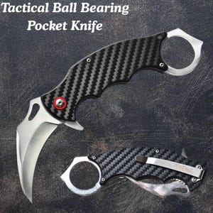 May include: A tactical ball bearing pocket knife with a curved blade and a carbon fiber handle. The knife features a silver finger ring and a red accent. The text "Tactical Ball Bearing Pocket Knife" is displayed at the top.