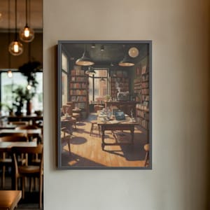 Könnte beinhalten: Ein gerahmter Druck eines gemütlichen Buchladen-Interieurs. Das Kunstwerk zeigt einen Raum voller Bücherregale, Tische und Stühle. Mehrere Pendelleuchten beleuchten die Szene. Ein Laptop steht auf einem Tisch, was auf einen Arbeitsplatz hindeutet.
