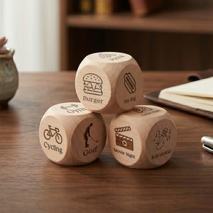 May include: Three wooden dice with engraved icons and text. One die shows a burger and the text "Burger", another shows a bicycle and the text "Cycling", and the third shows a movie clapper and the text "Movie Night".