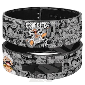 Peut inclure: Une ceinture de musculation noire et blanche avec un imprimé collage de manga One Piece. La ceinture présente divers panneaux de personnages, le logo One Piece et une illustration centrale en couleur d'un personnage dans une pose dynamique.