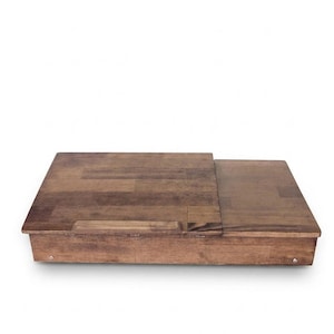Op de afbeelding: Een houten laptoptafel met een schuifblad. De tafel is gemaakt van donkerbruin hout en heeft een rechthoekige vorm. De bovenkant schuift open om een opbergruimte te onthullen. De tafel heeft een handvat.