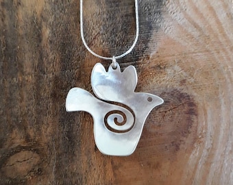 Pode incluir: Um colar de prata com um pingente em forma de pássaro. O pássaro tem um design em espiral em seu corpo e uma asa levantada acima de sua cabeça.