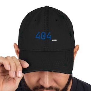 May include: Black distressed baseball cap with the number "404" embroidered in blue. The cap has a pre-curved visor and a distressed finish, giving it a worn look. The cap is a classic six-panel design.