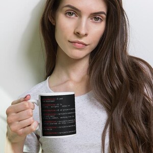 May include: A white ceramic mug featuring a black rectangular graphic printed with white and red computer terminal command line text. The text displays various directory paths and commands including pwd, ls, and git status on a dark background.
