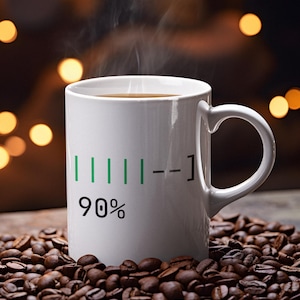 May include: A white coffee mug with a black handle, filled with coffee and steam rising from the top. The mug has a green and black graphic that reads "90%" on the side. The mug is surrounded by roasted coffee beans.