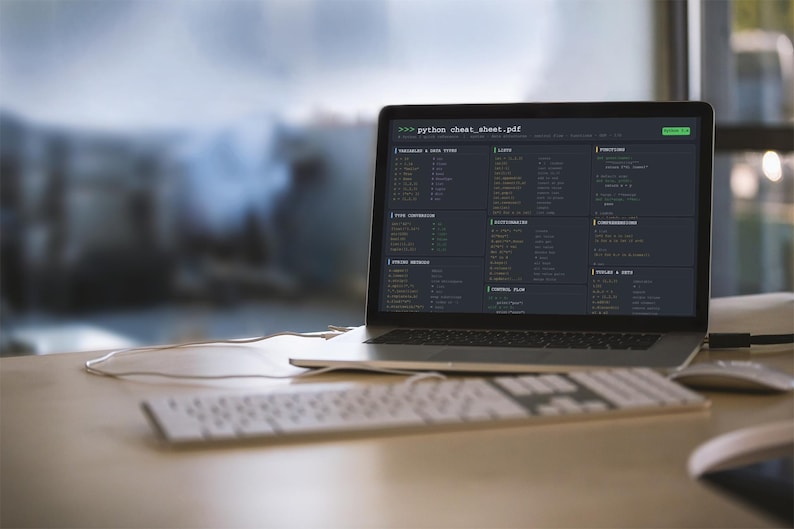 Pode incluir: Um laptop exibindo uma folha de dicas de Python em uma mesa de madeira. Um teclado e um mouse brancos est&atilde;o em primeiro plano. A tela mostra trechos de c&oacute;digo em um tema escuro. O fundo est&aacute; desfocado.
