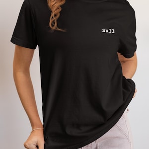 May include: Black crew neck t-shirt with the word "null" printed in white on the upper left chest. The model is wearing light pink trousers. The shirt has short sleeves.