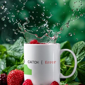 May include: White ceramic mug with the text "{ CATCH { Error" in black and red. Water splashes from the mug, with strawberries and raspberries around the base. Green foliage forms the background.