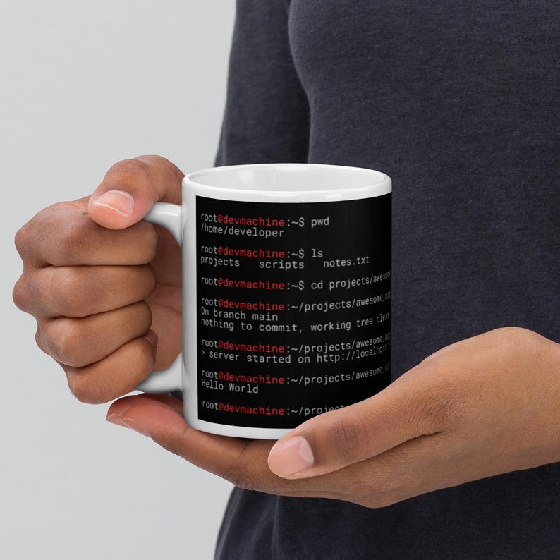 May include: A white ceramic mug featuring a black graphic print of a computer terminal command line interface. The text displays directory paths, file listings, and git status messages in white and red font against a solid black background.