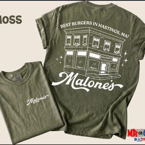 a green t-shirt with a graphic design of a building and the text "Malone's" printed on it.
