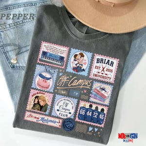 a gray t-shirt with various colorful and whimsical patches and illustrations, including a pair of jeans, a hat, and other objects.