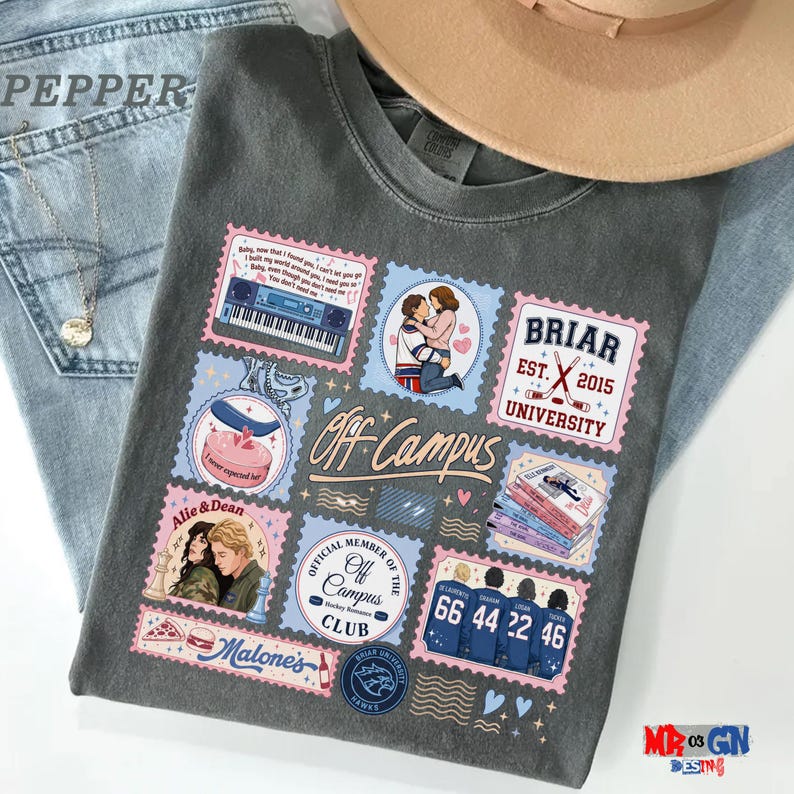 a gray t-shirt with various colorful and whimsical patches and illustrations, including a pair of jeans, a hat, and other objects.