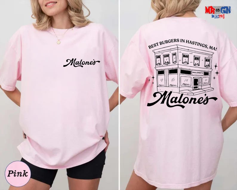 A woman wearing a pink t-shirt with a graphic design on the back.