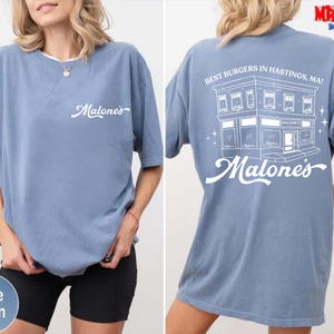 a woman wearing a blue t-shirt with a graphic design on the back.