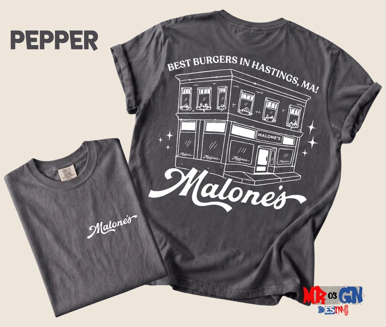 a gray t-shirt with a graphic design on the back, depicting a building and the text "Pepper" and "Best Burgers in Hastings, MA!"