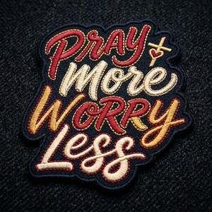 May include: Embroidered patch with the words "Pray More Worry Less" in a cursive font. The patch features red, white, and gold thread on a navy blue background. A small cross and heart are included in the design.