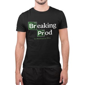 May include: Black t-shirt featuring the words "Breaking Prod" in white and green, with the phrase "It Worked in Dev." underneath. The design is styled like a periodic table, with "404" and "500" above "Breaking" and "Prod".