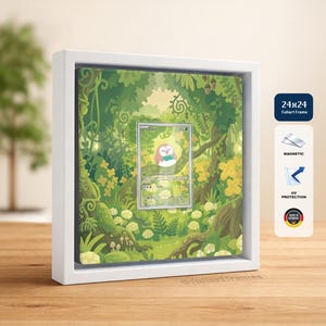 May include: A white square frame containing a Rowlet trading card centered against a green forest illustration. The frame features magnetic closure, UV protection, and a 24x24 size label. The design includes vines, leaves, and yellow flowers.