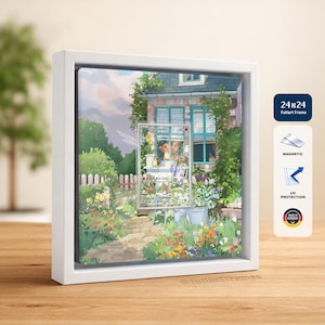 Op de afbeelding: Een ingelijste print met een witte rand, met een kleurrijke tuinscène met een huis en een winkel. De print is 61x61 cm groot en heeft een magnetische achterkant en UV-bescherming. Gemaakt in Duitsland.