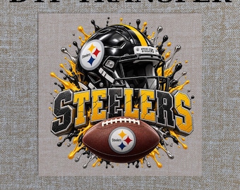 Könnte beinhalten: Ein DTF-Transfer mit einem schwarz-gelben Football-Helm der Pittsburgh Steelers und einem braunen Football mit Team-Logo. Das Design enthält schwarze und gelbe Farbspritzer und den Schriftzug STEELERS. Der Text lautet DTF TRANSFER READY TO PRESS.