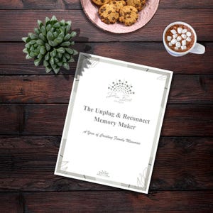 Pode incluir: Uma composição plana com uma suculenta, biscoitos com pepitas de chocolate num prato rosa e uma caneca de chocolate quente com marshmallows. Um documento branco com o texto "The Unplug & Reconnect Memory Maker" também está presente.