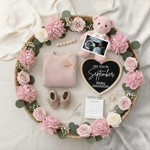 May include: A baby announcement arrangement featuring a pink teddy bear, ultrasound image, and a heart-shaped chalkboard that reads "See You in September Baby Swanson." Includes a pink sweater, shoes, and a calendar.