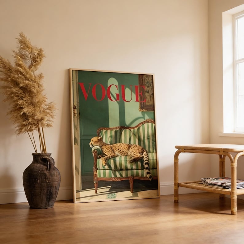 Puede incluir: Una portada enmarcada de la revista Vogue con un guepardo descansando en un sof&aacute; a rayas verdes y blancas. La palabra "VOGUE" est&aacute; en rojo. La obra de arte se exhibe en una habitaci&oacute;n con un jarr&oacute;n de plantas secas y una peque&ntilde;a mesa de madera.