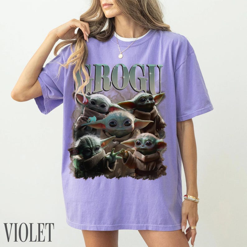K&ouml;nnte beinhalten: Violettes T-Shirt mit einer Grafik von Grogu aus The Mandalorian. Das Design zeigt mehrere Bilder von Grogu in verschiedenen Posen. Das Wort "GROGU" ist oben in einer Farbverlaufs-Schriftart aufgedruckt. Das Wort "VIOLET" ist unten aufgedruckt.