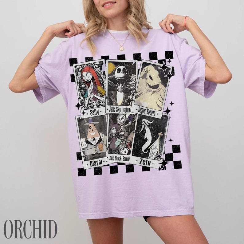 May include: A light purple t-shirt featuring character cards from The Nightmare Before Christmas. The cards include Sally, Jack Skellington, Oogie Boogie, Mayor, Lock, Shock, Barrel, and Zero. The word "ORCHID" is printed at the bottom.