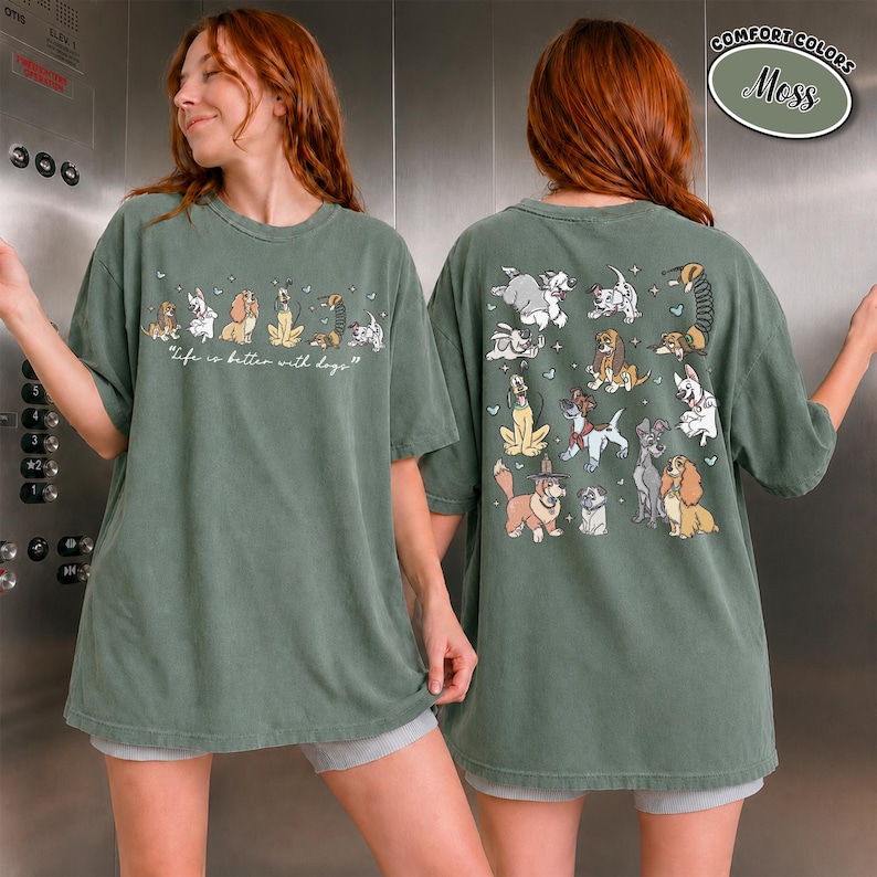 Puede incluir: Camiseta verde musgo con varias ilustraciones de perros. La parte delantera muestra una l&iacute;nea de perros y el texto "Life is better with dogs". La parte trasera de la camiseta tiene m&aacute;s ilustraciones de perros. La camiseta es de color confort.