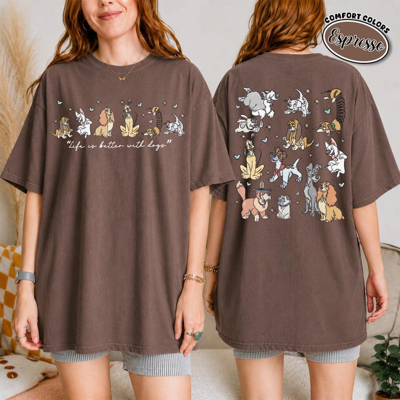 Puede incluir: Camiseta color espresso con dise&ntilde;o de perros. La parte delantera muestra perros de dibujos animados y el texto "Life is better with dogs". La parte trasera muestra varias ilustraciones de perros. La camiseta tiene mangas cortas y un corte holgado.