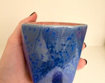 Taza de cerámica única hecha a mano: exterior azul y interior coral suave.