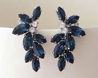 May include: A pair of silver earrings with a cluster of dark blue marquise-shaped crystals. The crystals are arranged in a cascading pattern, creating a delicate and elegant look.