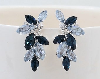 May include: A pair of silver earrings with a cluster of blue and light blue marquise-shaped crystals.