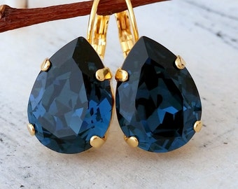May include: Gold teardrop earrings with dark blue crystal stones.