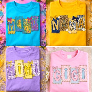 May include: Four colorful t-shirts with the words "MAMA", "NANA", "MIMI", and "GIGI" printed on them. Each word is in a different color and style, with decorative bows and patterns. The shirts are blue, yellow, purple, and pink.