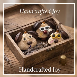 May include: Three handcrafted ornaments shaped like animal heads with dark brown seed ears, wooden bead accents, and white or yellow sunglasses, resting in a wooden box with dried lavender sprigs and the text Handcrafted Joy.