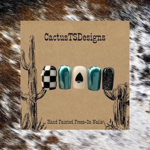 May include: Hand-painted press-on nails in a variety of designs. The set includes a black and white checkered nail, teal nails, a white nail with a black spade, and a glitter nail. The card reads "CactusTSDesigns".