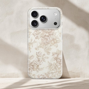 Può includere: Custodia trasparente per telefono con motivo floreale beige e crema. La custodia ha un bordo trasparente e un modulo fotocamera con tre lenti e un flash.