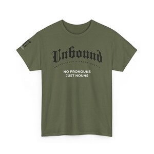 May include: Olive green t-shirt with the word "Unbound" in a gothic font. Below the word "Unbound" are the words "Uncancelled & Unapologetic". Underneath is the phrase "No Pronouns Just Nouns".