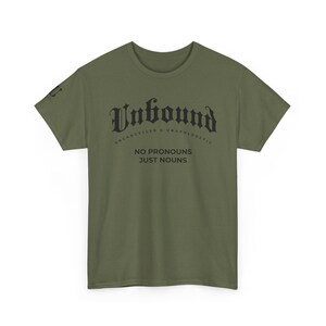 May include: Olive green t-shirt with the word "Unbound" in a gothic font, with the phrases "Uncancelled & Unapologetic" and "No Pronouns Just Nouns" printed below. The shirt is made of a soft material.