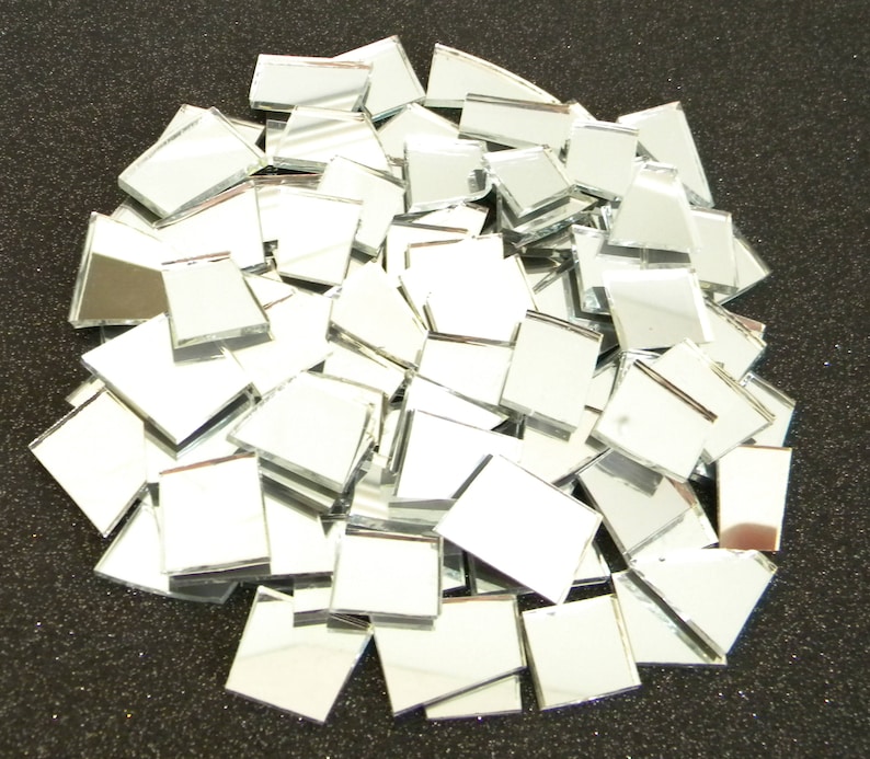 May include: A pile of small, square, silver mirror tiles. The tiles are arranged in a random pattern and are all the same size.