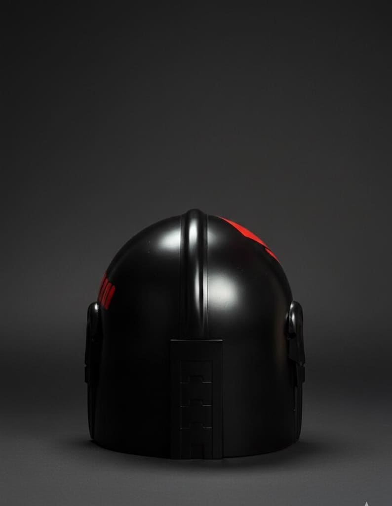 Op de afbeelding: Een zwarte helm met rode accenten. De helm heeft een gladde, glanzende afwerking en een gestroomlijnd ontwerp. Rode markeringen zijn zichtbaar op de boven- en zijkant. De helm is waarschijnlijk voor bescherming.