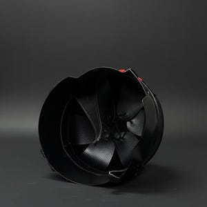 Op de afbeelding: Zwarte leren helm met een afgeronde vorm en een gedetailleerd interieur. Het interieur heeft leren panelen en riemen. Een klein rood accent is zichtbaar aan de buitenkant. De helm is ontworpen voor bescherming.