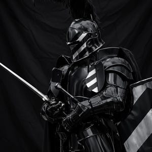 May include: A black and white image of a knight in full armor. The armor is glossy black with white stripes on the helmet and shield. The knight holds a sword and has a feathered plume on the helmet. The background is a dark curtain.