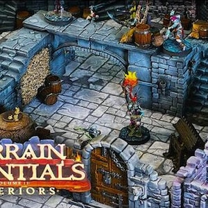 May include: A detailed miniature dungeon terrain set with stone walls, archways, and stairs. The set includes barrels, torches, and figures, with the text "TERRAIN ESSENTIALS VOLUME II INTERIORS" at the bottom. Ideal for tabletop gaming.