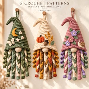 Peut inclure: Trois décorations murales en crochet en forme de gnomes avec des barbes tressées. Celui de gauche est vert avec une lune, des étoiles et un papillon. Le centre est crème avec une citrouille, un gland et du blé. Celui de droite est rose avec des fleurs et un escargot. Texte : 3 CROCHET PATTERNS.